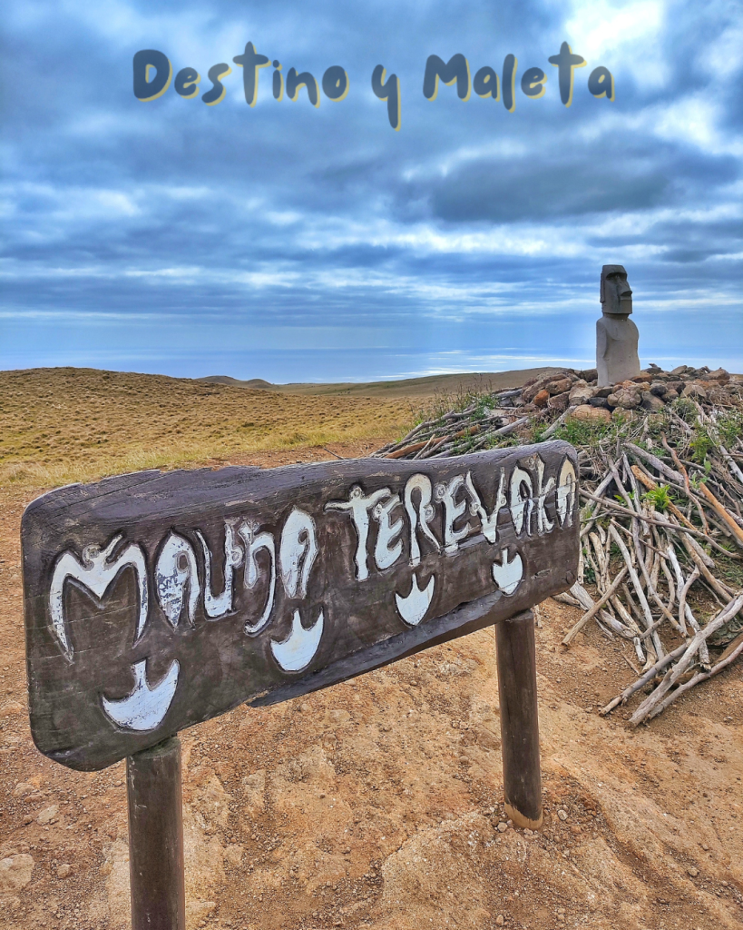 imagen de la cima del montse terevaka, con un cartel de madera con el nombre y un montículo de madera con un moái
