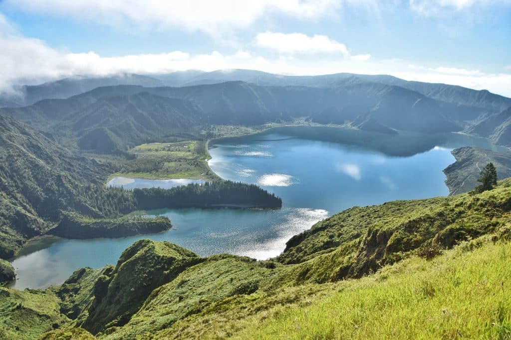 Vista panorámica de la Lagoa do Fogo tomada desde el Miradouro do Pico da Barrosa, mostrando la laguna volcánica rodeada de montañas y vegetación