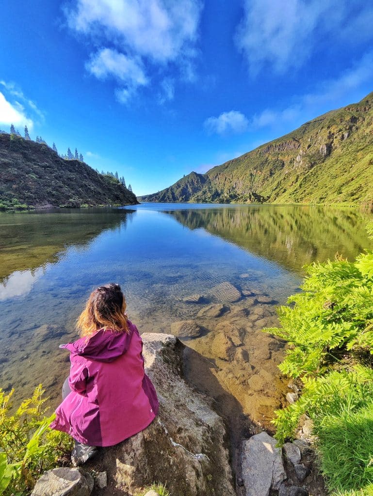 Montse de despaldas en la orilla de Lagoa do Fogo. PR02 SMI (variante) – Mirador Lagoa do Fogo – Orilla del Lago