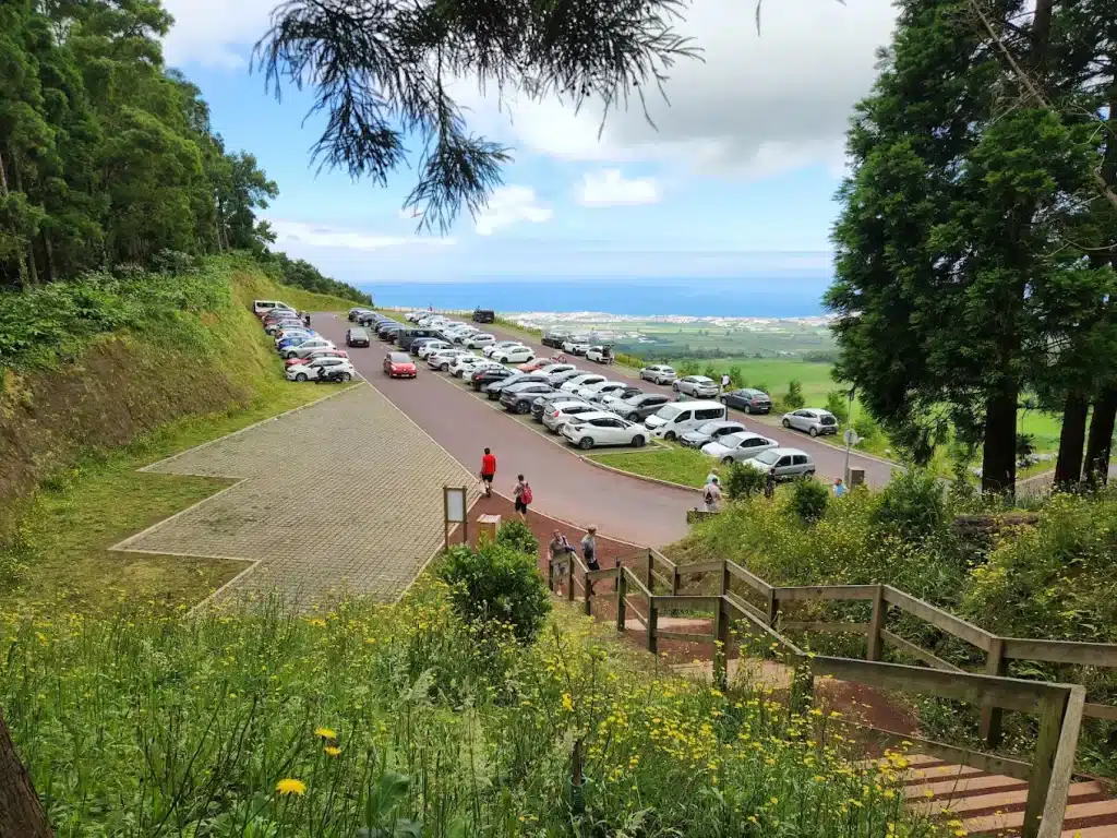 Parking de Caldeira Velha visto desde una zona elevada, con coches aparcados.