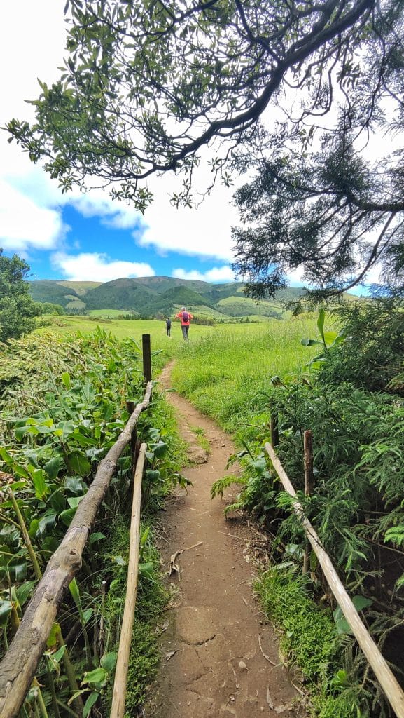 Tramo de la PRC37 SMI Rota da Água donde el sendero llega a un prado verde después de cruzar el río por una escalera; Domi continúa la ruta.