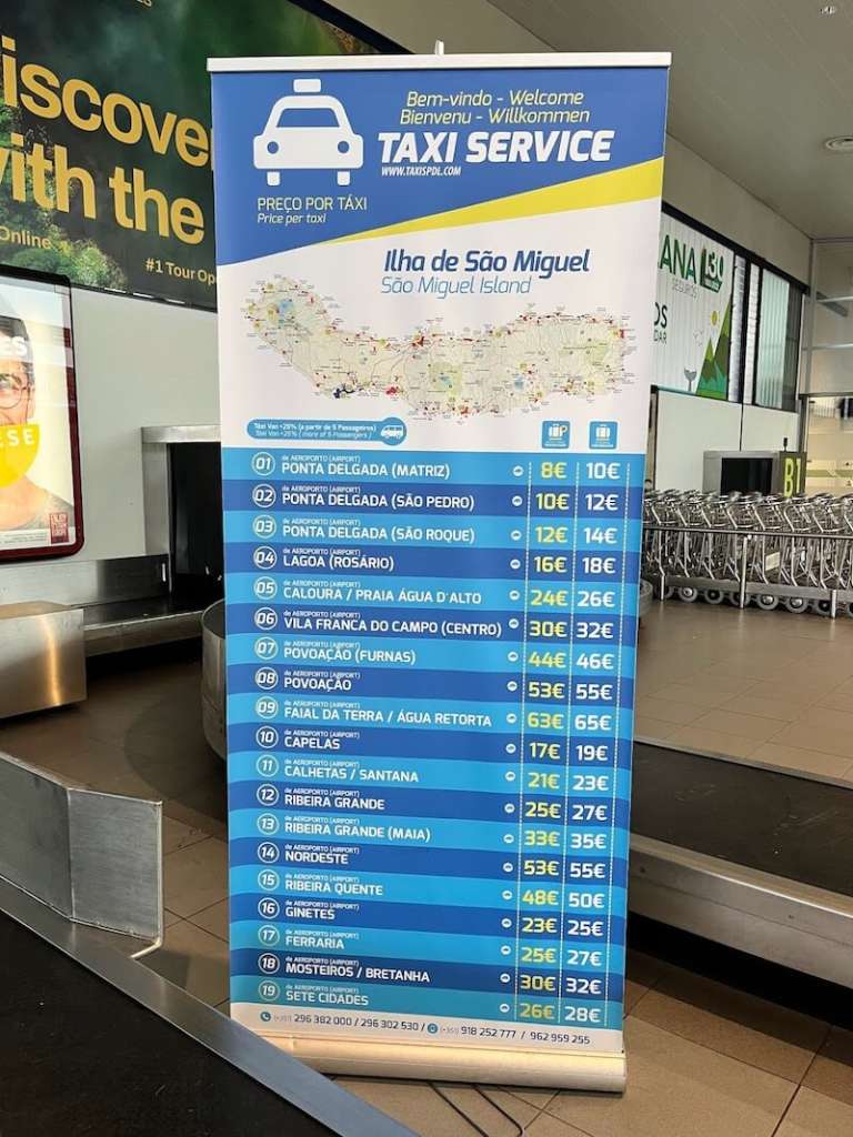 Roll up en el aeropuerto de Ponta Delgada que muestra las tarifas fijas oficiales de los taxis hacia distintos destinos de São Miguel