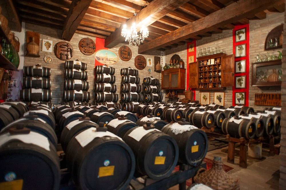 Interior de la Acetaia San Matteo con filas de pequeñas barricas de madera utilizadas para el envejecimiento del vinagre balsámico tradicional.