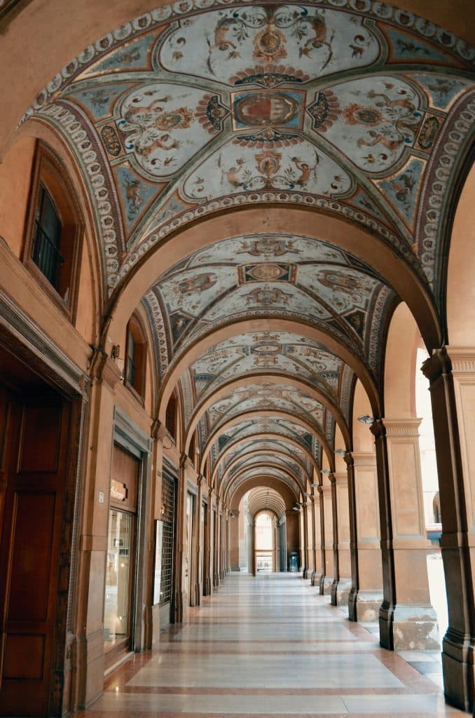 Pórticos de Bolonia con arcos sucesivos y techos decorados, característicos del centro histórico de la ciudad.