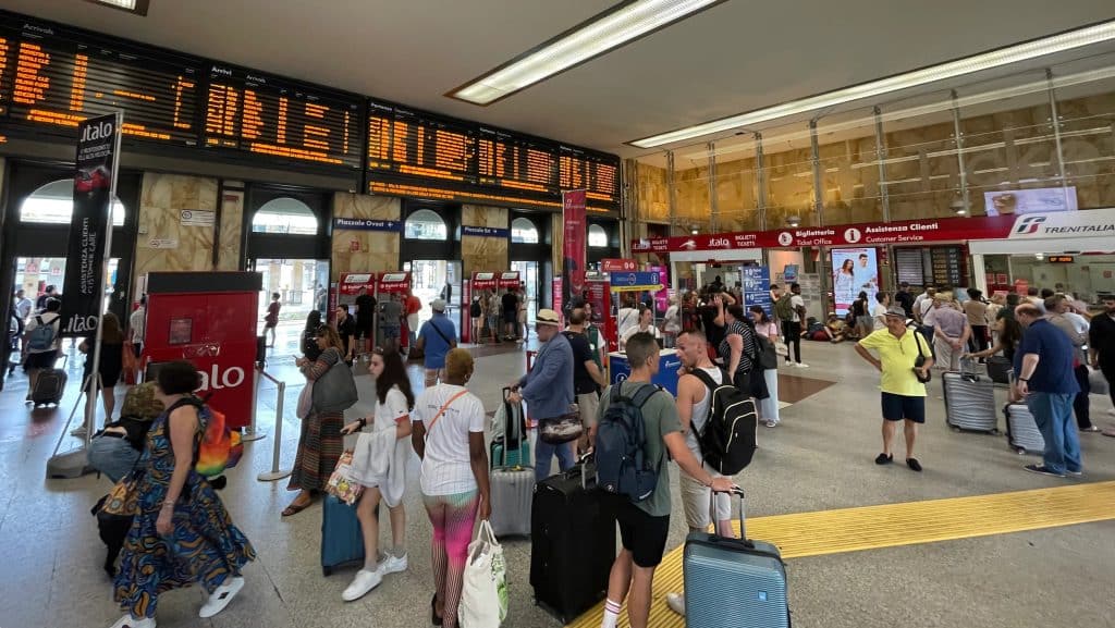 Estación de tren Bologna Centrale con andenes y trenes, centro neurálgico del transporte ferroviario en Emilia‑Romaña.