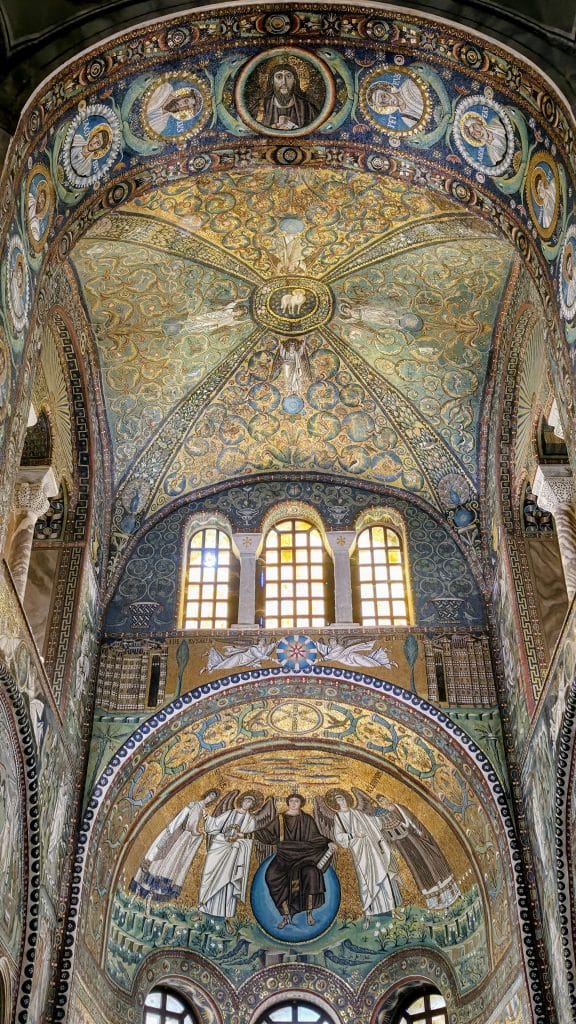 Ábside y arco triunfal de la basílica de San Vitale en Rávena, cubiertos de mosaicos bizantinos con fondo dorado y figuras religiosas.