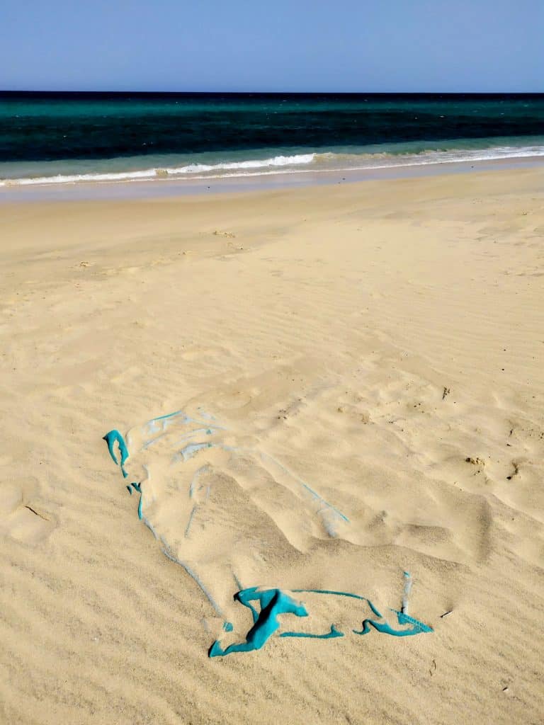 toalla-de-playa-enterrada-en-arena-en-una-playa-de-fuerteventura