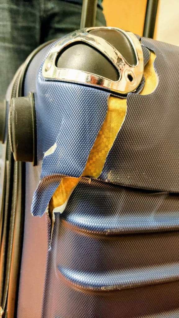 Fotografía real de una maleta dañada durante un viaje tras llegar al aeropuerto.