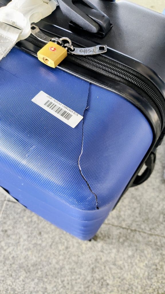 Fotografía real de una maleta dañada durante un viaje tras llegar al aeropuerto.